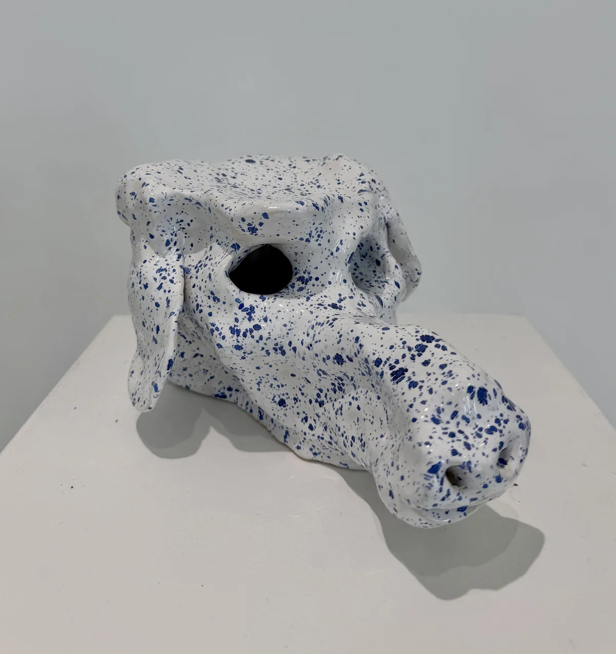 Ceramic no. 3: an animal head with a long muzzle, white glaze speckled with blue, an empty eye socket