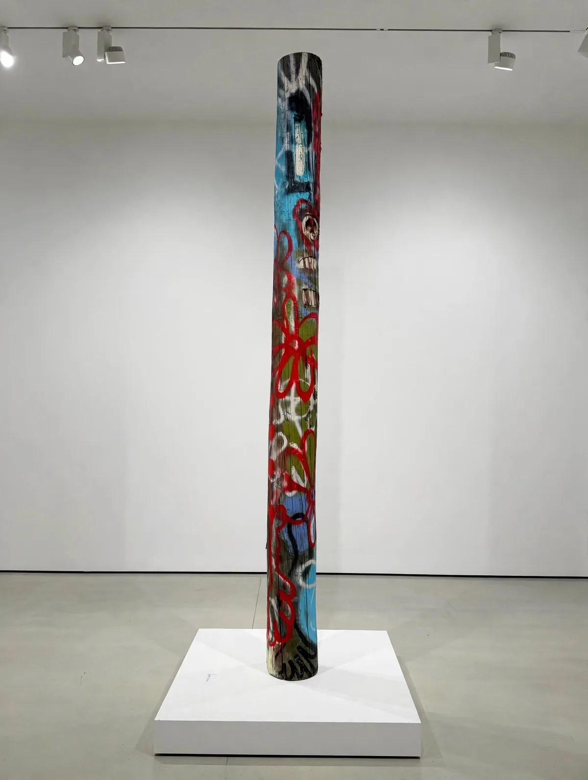 Totem (visage) on a white plinth, in a white gallery